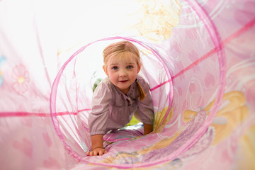 Junges M&auml;dchen kriecht im SpielzeugTunnel