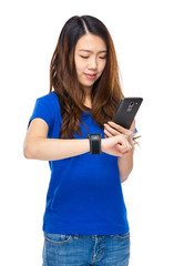 Fototapeta premium Woman use smartphone to connect with wearable watch