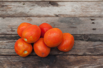 Fototapeta na wymiar Fresh tomatoes on vintage wooden table..