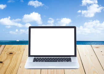 Blank screen laptop on wooden with seascape background