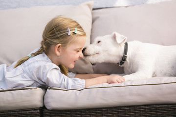 Junges Mädchen liegt mit ihrem Hund auf Sofa