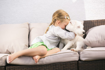 Junges Mädchen umarmt ihren Hund auf Sofa