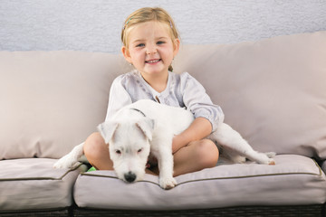 Junges Mädchen umarmt ihren Hund auf Sofa