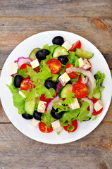 Greek salad (top view) on a wooden table