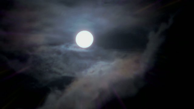 Magic full moon and white clouds on nightly sky