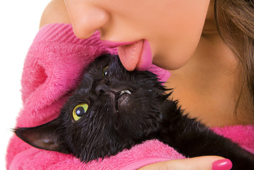 Woman licking Cute black soggy cat after a bath