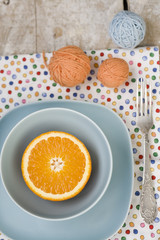 Juicy orange on blue plate for breakfast and bright balls