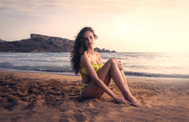 Fototapeta na wymiar beautiful young woman sitting on the beach