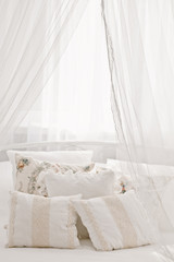 Fototapeta na wymiar White cozy bed with vintage pillow