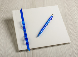 Pen and wedding wish book on the grey wood table