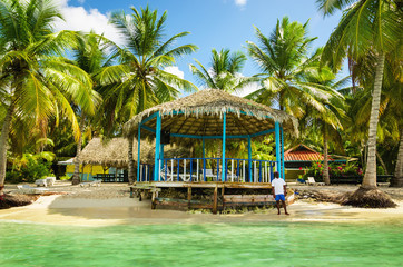 Beach hut on coast of the exotic island full of palm trees