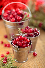 Cranberries in buckets against de-focused holiday lights backgro