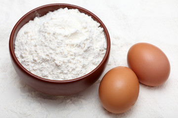 Flour in bowl and two eggs