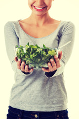 Young casual woman eating lamb's lettuce.