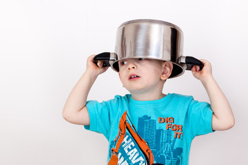 Fototapeta na wymiar Child holding cooking pot on his head