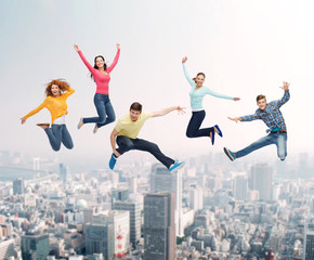 Fototapeta na wymiar group of smiling teenagers jumping in air
