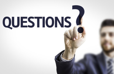 Business man pointing the text: Questions?