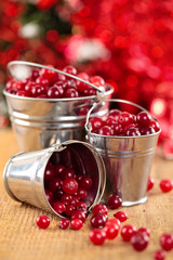 Cranberries in buckets against de-focused holiday lights backgro