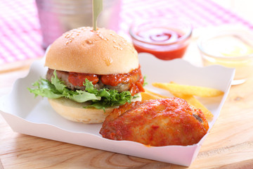 homemade hamburgers and chicken wing on wooden board