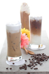 Three Ice coffee with flower and coffee beans on a table