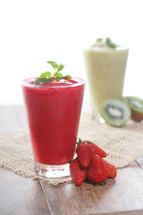 strawberry smoothie with strawberries on a wooden table