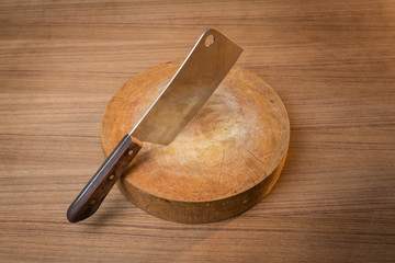 Knife on a wooden butcher on wooden background.