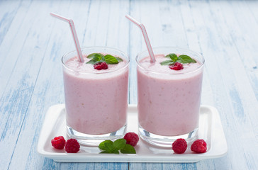 Milkshake with fresh raspberries in a glass