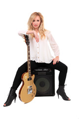 Fototapeta premium Woman with guitar sitting on an amplifier