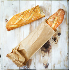 Baguette in a grocey paper bag. Loaf of bread