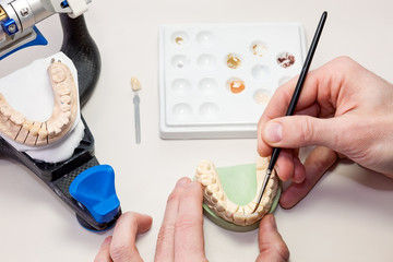 Making facial dental prosthesis on white table.