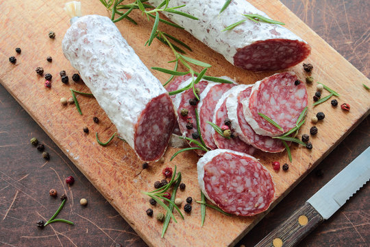 Salami on a cutting board with herbs