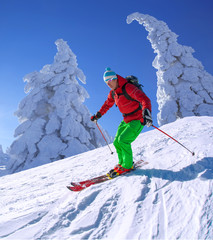 Skier against blue sky in high mountains