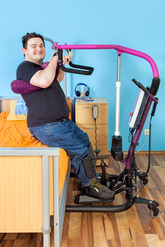 Young man with cerebral palsy using a patient lift.