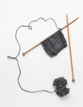 Piece of grey knitting on knitting needles
