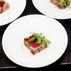 Fototapeta na wymiar juicy filet mignon cutted on white plate with rocket