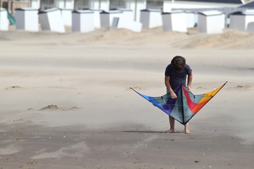 Junge mit Drachen am Strand