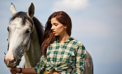 Obraz premium An attractive young woman with a horse