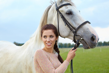 An attractive young woman with a horse