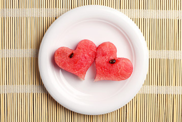 Obraz na płótnie Canvas Two watermelon slices in the shape of hearts