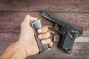 hand with bullet and Semi-automatic 9mm gun