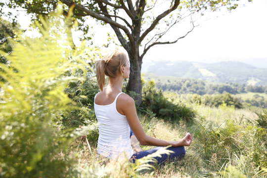 Woman in countryside doing yoga exercices