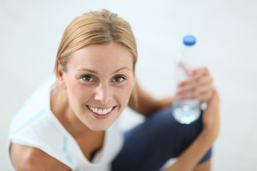 Closeup of fitness girl drinking water after exercising