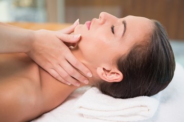 Fototapeta na wymiar Attractive woman receiving neck massage at spa center