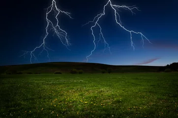 Fotobehang Thunderstorm with lightning in green meadow © klagyivik