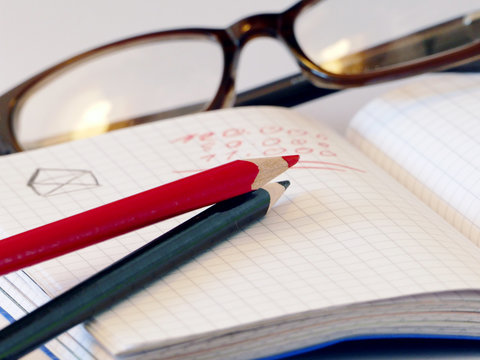 Notitzbuch mit Stiften und Brille