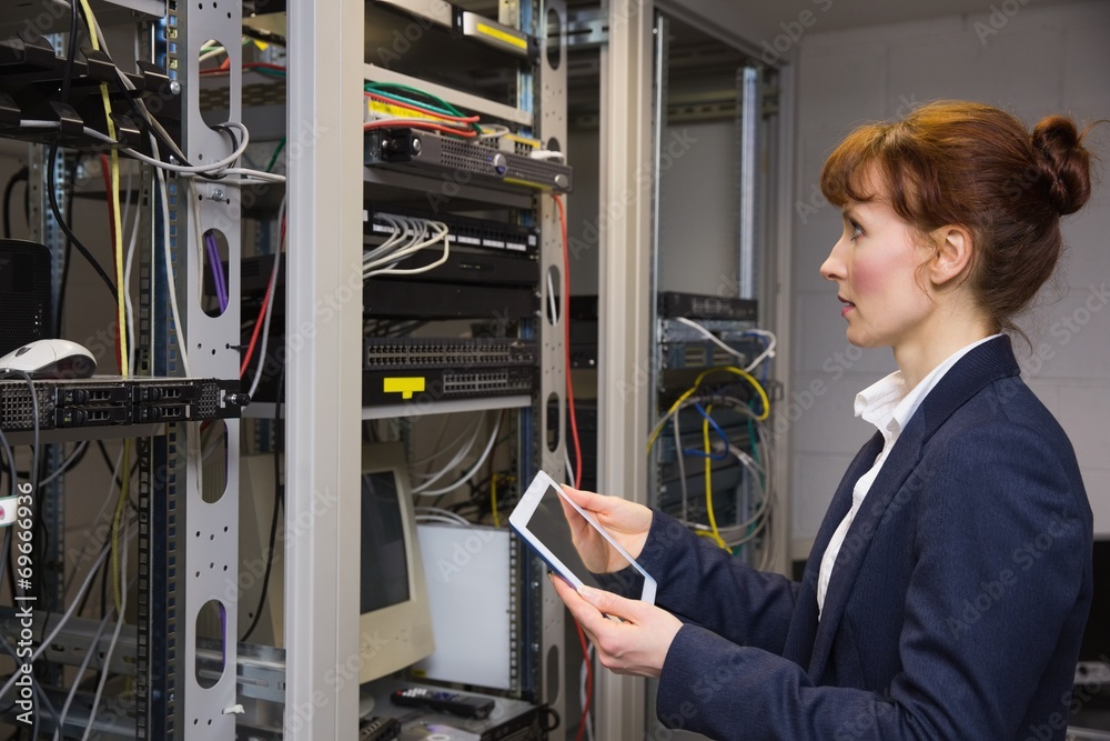 Aufkleber Pretty technician using tablet pc while looking at server