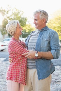 Happy mature couple hugging in the city