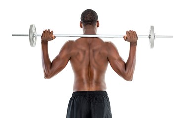 Fototapeta na wymiar Rear view of a fit shirtless man lifting barbell