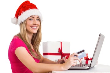 Festive blonde shopping online with laptop