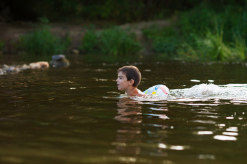 A boy swims in the river